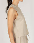 Close side view of the taupe P.CILL Birdie tank showing the cut-in armhole and straight hem