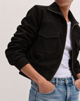 Model wearing the P.CILL Reid Utility Jacket in Black unzipped over a white tee with light wash jeans, showing chest flap pockets