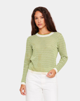 Model wearing D.RA Cori green and ivory striped knit top with long sleeves and fitted silhouette.