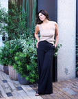 Taupe Kate Knit Top with scoop neck tucked into black wide-leg trousers, hand on hip