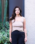 Taupe Kate Knit Top, a sleeveless ribbed knit tank, worn with black wide-leg trousers by a garden wall