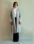 Gentle Fawn SoHo overcoat in light heather grey worn open over a white shirt and dark wide-leg trousers