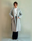 Grey SoHo Belted Overcoat worn open with hands in the front patch pockets