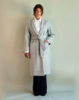 Light heather grey SoHo Belted Overcoat tied at the waist over a white shirt and navy trousers, front view