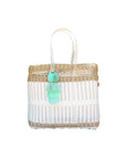 Close-up of the Coastal Net Tote showing white and tan woven bands, braided handles and fluffy mint tassel pom