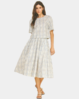 Model wearing the Azure Horizon Top matching set featuring a soft blue and ivory print with a relaxed silhouette and coordinating midi skirt.