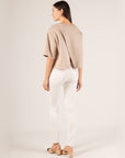 Back view of the taupe P.CILL Hazel Overlap Back Top over white jeans and slingback heels