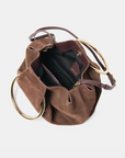 Channing suede bag by Dolce Vita featuring a smooth suede finish and gold O-ring detail.