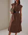 Model wearing the Modern Icon Shift Dress in Chocolate with a black belt and snakeskin clutch, front view