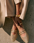 Model wearing Dolce Vita Baylee Woven Ballet Flats in gold with neutral trousers