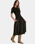 Model wearing the Elan Ember mixed media midi dress in black styled with tall suede boots.