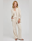 Model in Gentle Fawn Finley drawstring linen pants and matching Portia shirt in a cream and brown stripe