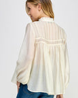 Side view of ivory sheer long sleeve blouse with flowy silhouette