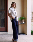 Side view of the Modern Muse Button Down Blouse in ivory featuring contrast trim, short sleeves, and an effortless relaxed fit.