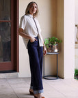 Modern Muse Button Down Blouse in ivory, half-tucked into dark wide leg jeans with brown suede wedge sandals