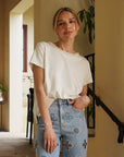 Monaco Pearl Trim Tee in ivory featuring an elegant pearl-trim neckline and relaxed short sleeve silhouette.