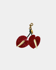 Oceans End anthurium bag charm in red with gold clasp and green stem detail
