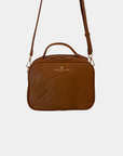 Oceans End Justine 2.0 crossbody bag in saddle featuring an embossed hibiscus design, top handle, adjustable crossbody strap, and gold-tone hardware.