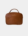 Front view of the Oceans End Justine 2.0 saddle crossbody handbag showcasing the embossed tropical hibiscus artwork and structured silhouette.
