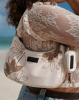 Model wearing the Oceans End Kamalani creme shoulder bag at the beach