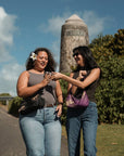 Two women walking outdoors with Oceans End Kamalani bags in black and purple