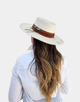 The Petra Savage Tasha Boater Hat styled on a model in neutral fashion styling.