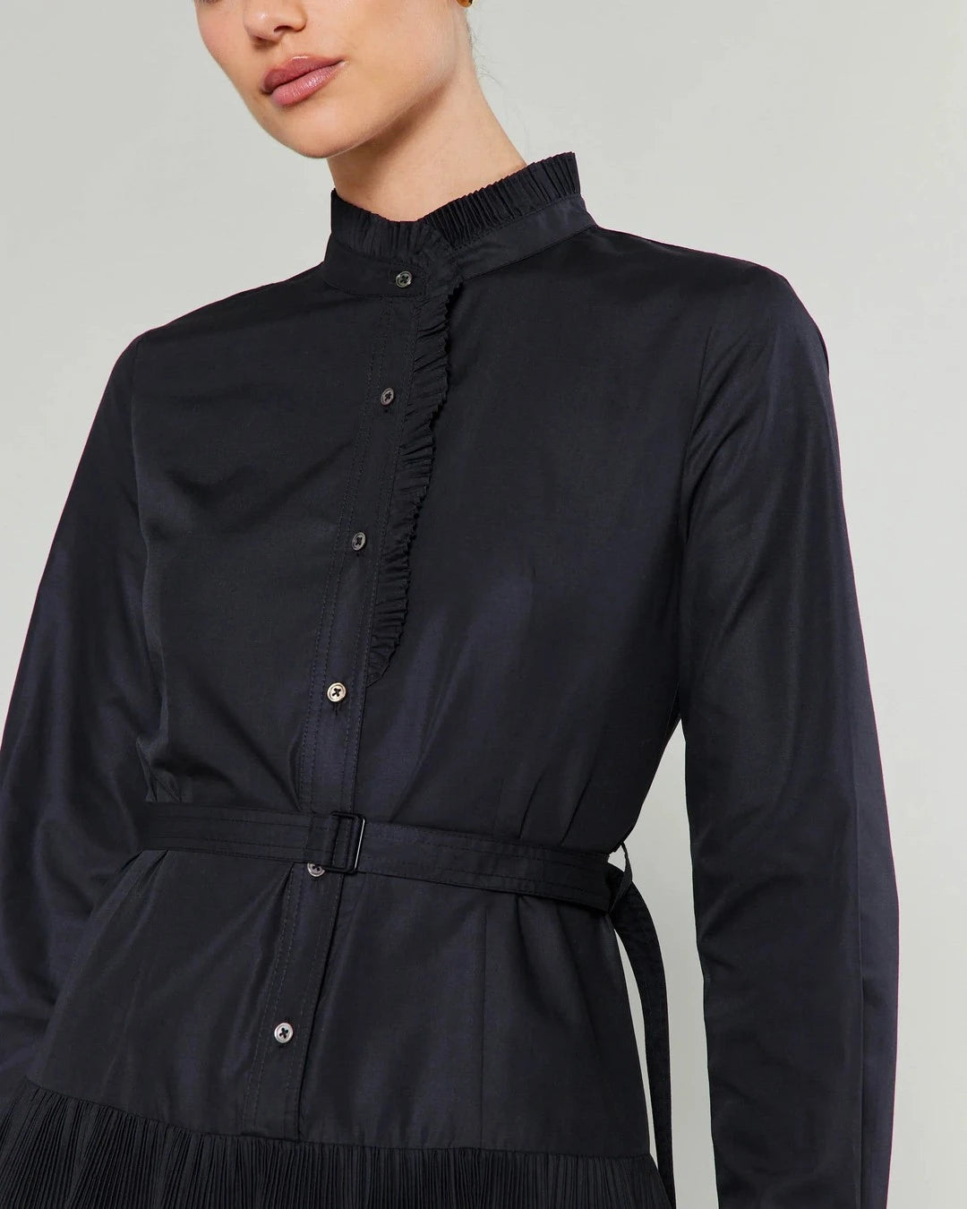 Close-up of the black Anberlin Mini Dress bodice with ruffled stand collar, button placket and belt