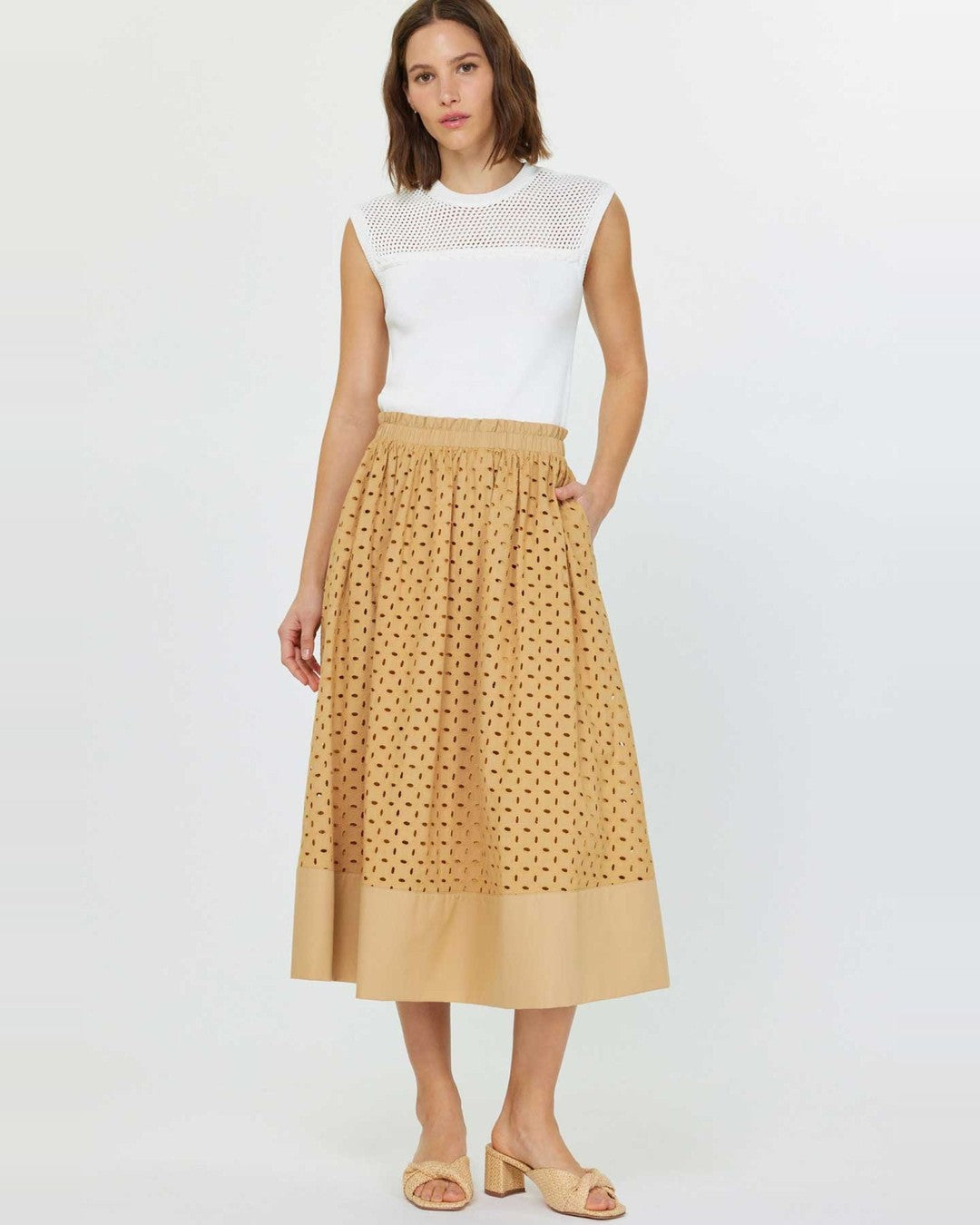 Model in the butterscotch eyelet midi skirt with a white sleeveless top and tan sandals