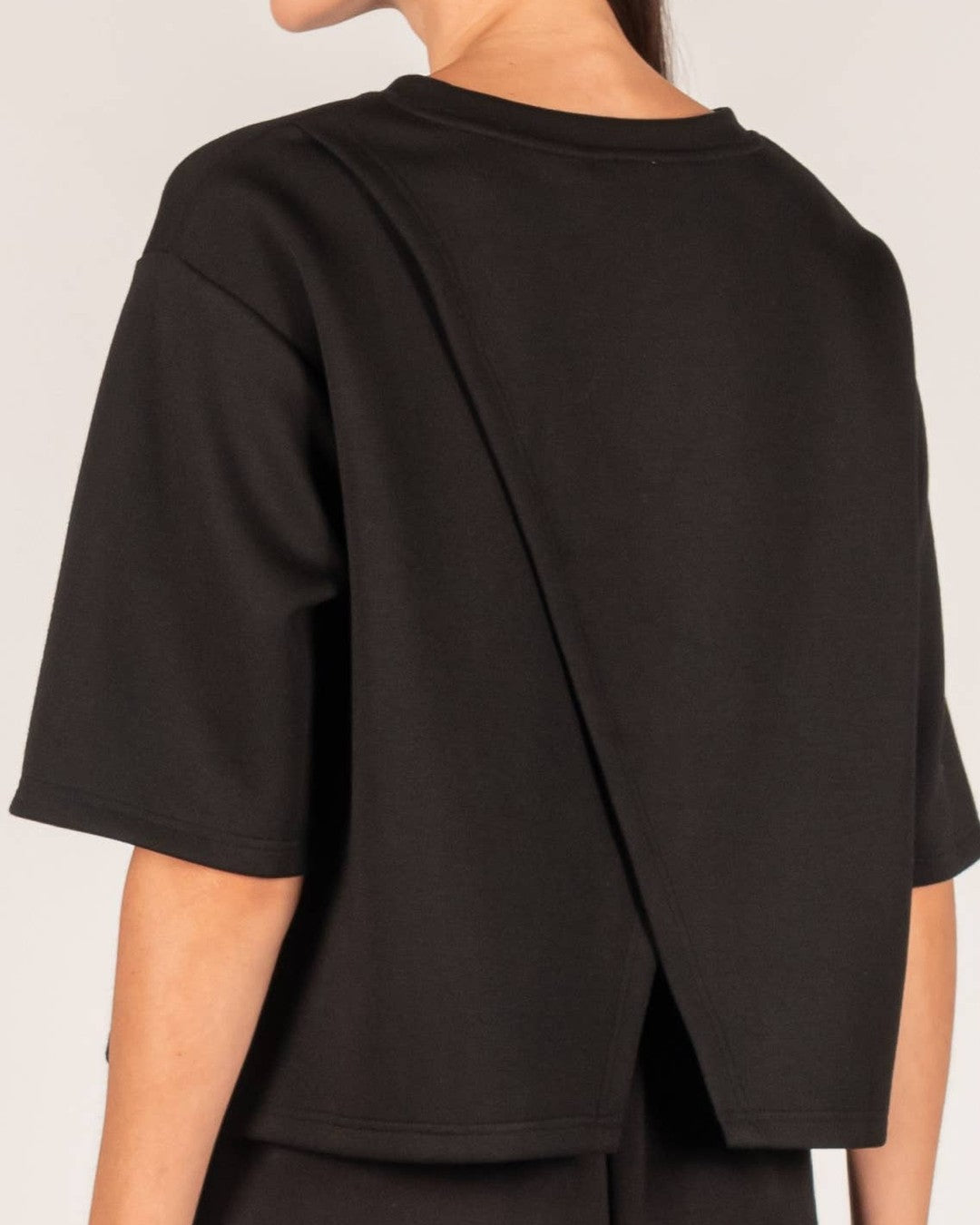 Back detail of the black P.CILL Hazel top showing the overlapping split back panels