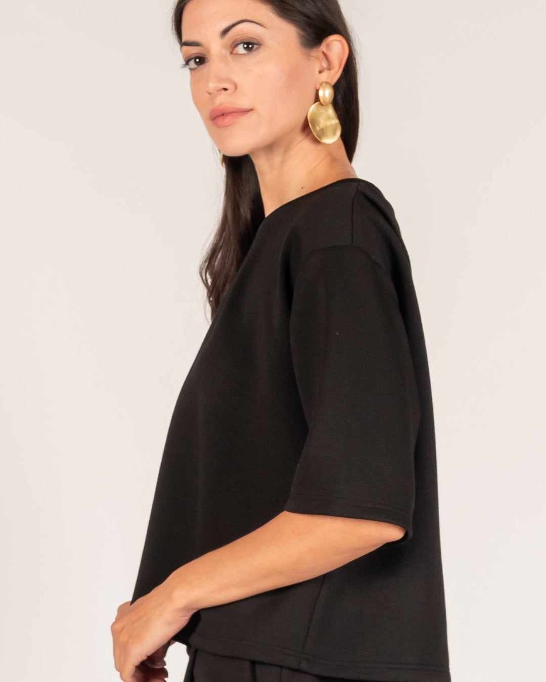 Close side view of the black Hazel top with dropped shoulder and three-quarter sleeve