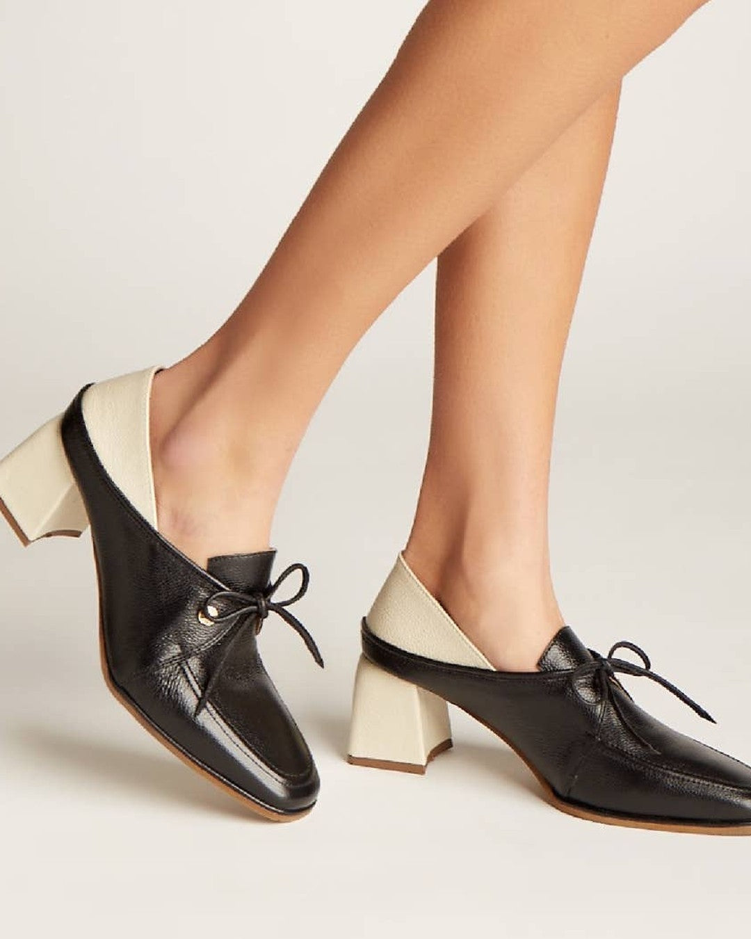 Side view of the Stivali Focus heeled loafer showing the off-white block heel