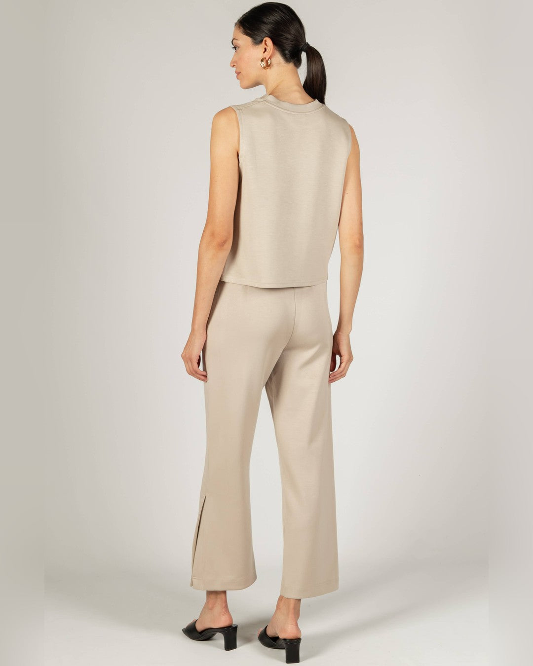 Back view of the taupe Birdie Boxy Tank Top with cropped side-slit pants