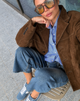 Dolce Vita Shyla blue suede sneakers styled with jeans, a blue shirt and a brown jacket