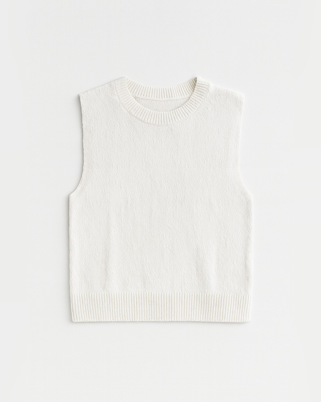 Flat lay of the cream CeCe Sleeveless Open Back Sweater with ribbed crew neck and hem