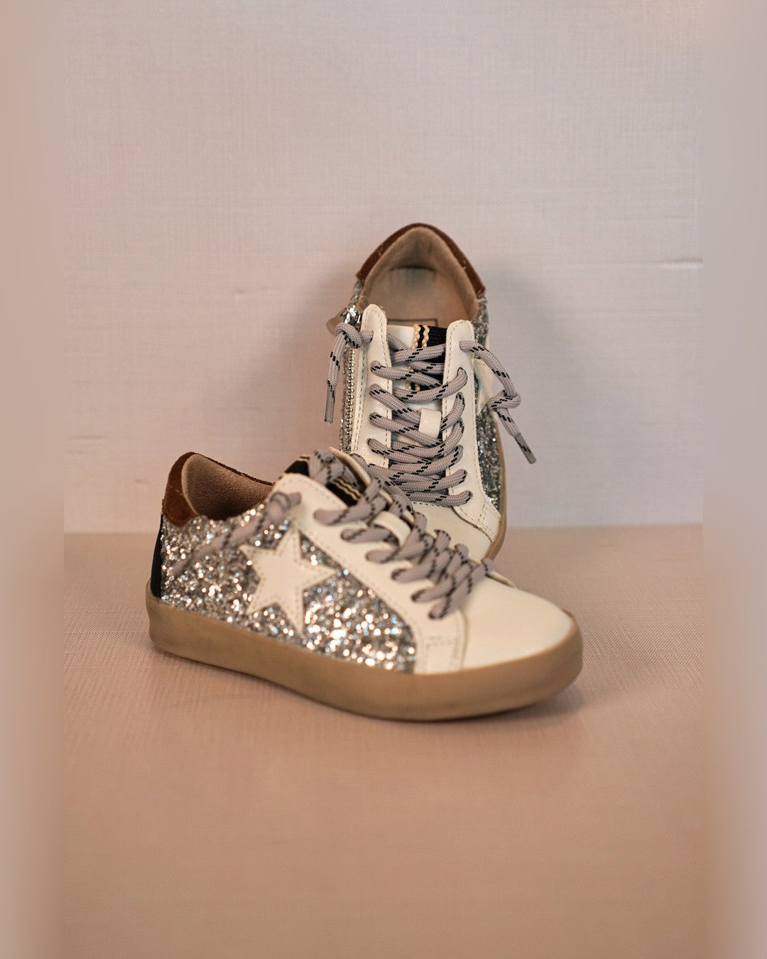 Shushop Paula glitter toddler sneakers stacked on a wood surface