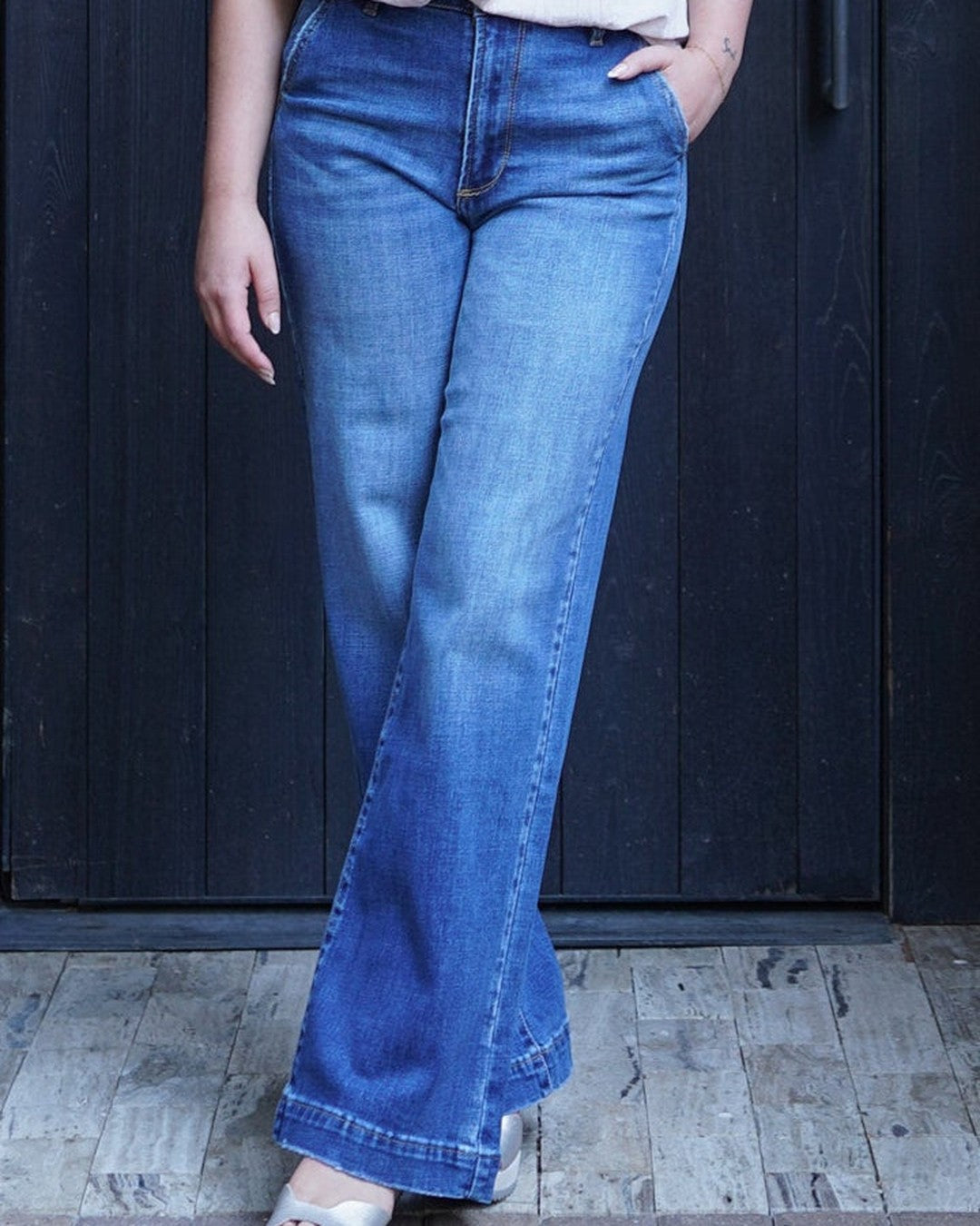 KanCan high-rise wide-leg denim trousers in a medium wash, worn with platform sandals