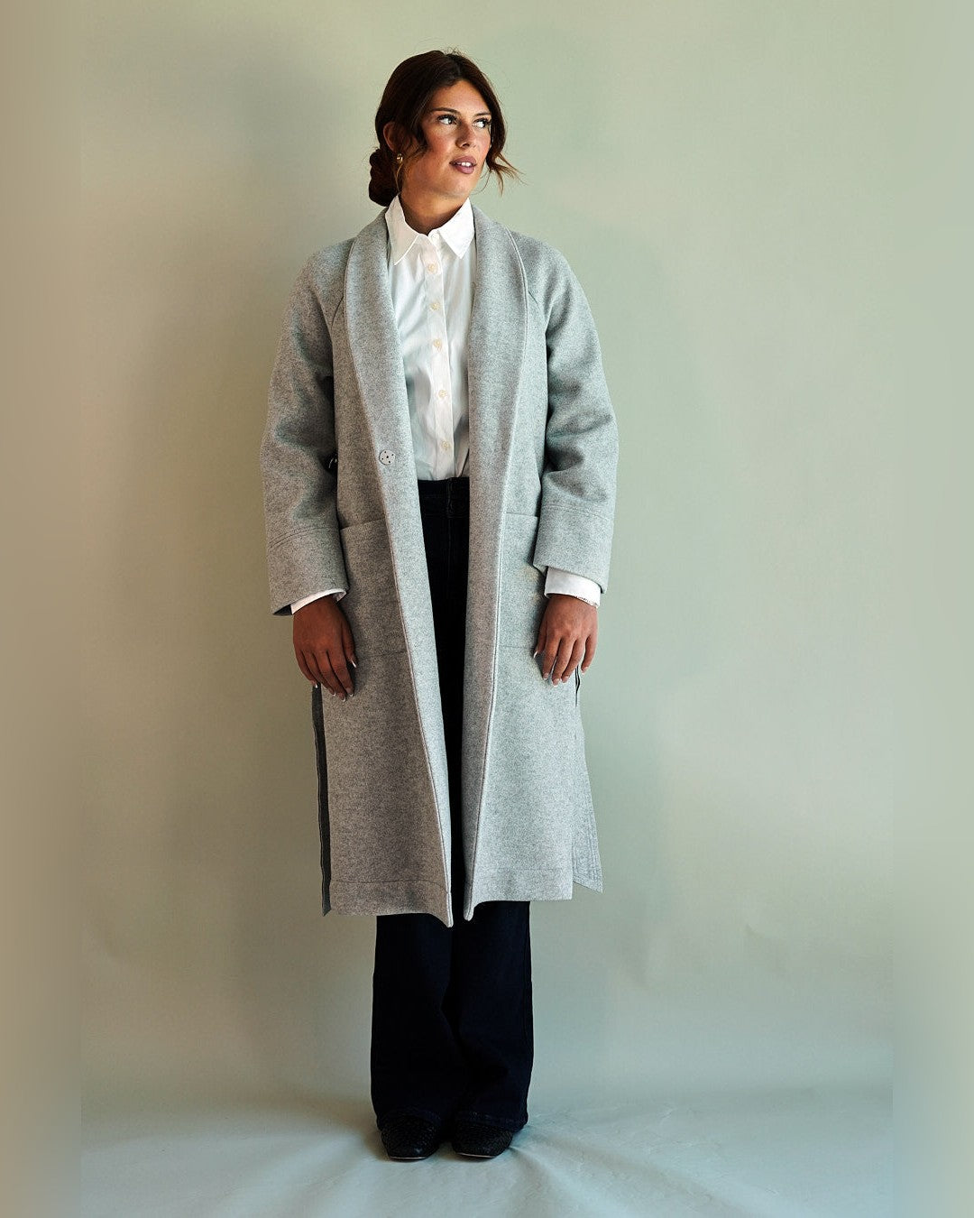 Gentle Fawn SoHo overcoat in light heather grey worn open over a white shirt and dark wide-leg trousers