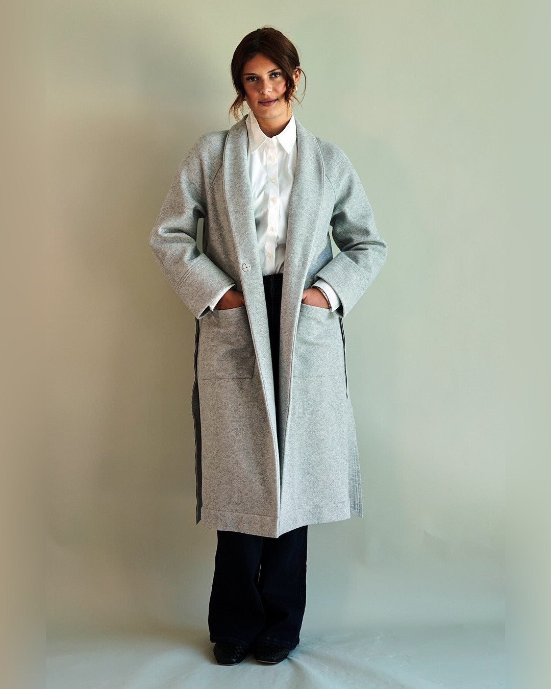 Grey SoHo Belted Overcoat worn open with hands in the front patch pockets