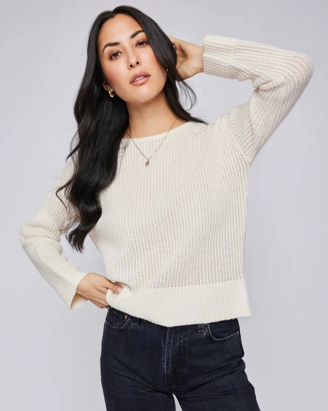 Model wearing the Gentle Fawn Ambrose pointelle sweater in cream with dark wide-leg jeans, front view