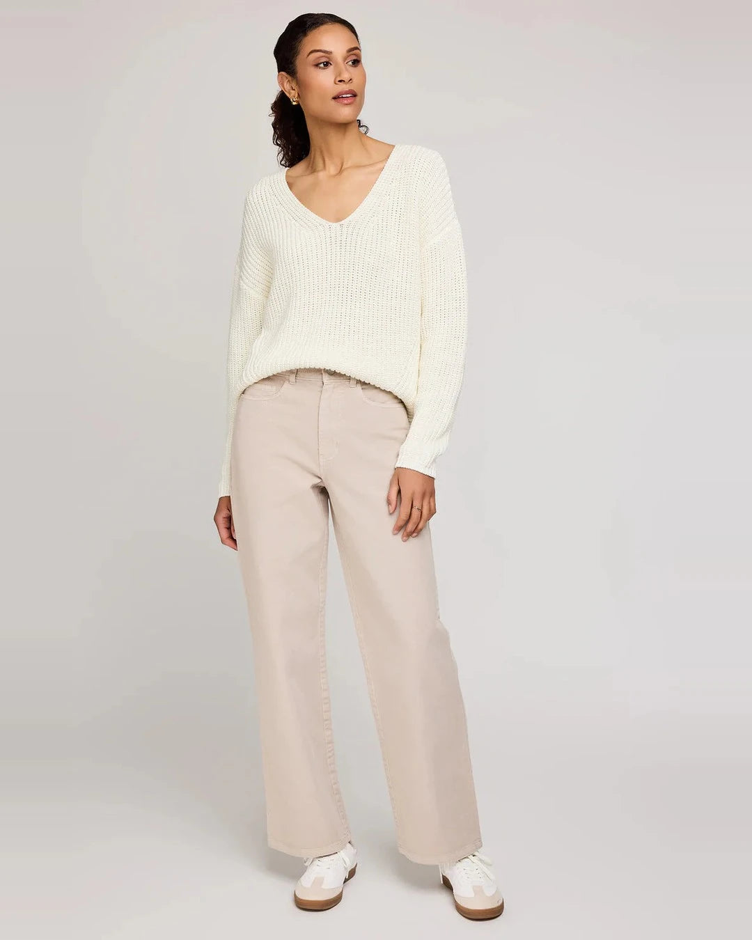 Model in Gentle Fawn Everett high-rise wide-leg pants in pebble with a cream V-neck sweater