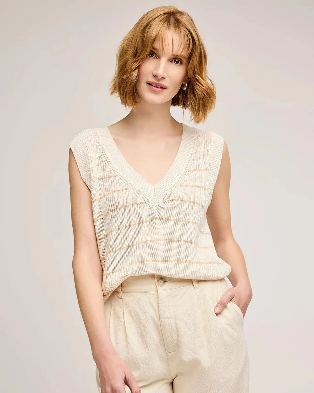 Gentle Fawn Tanner Knit Vest in cream with tan stripes worn with cream trousers, front view