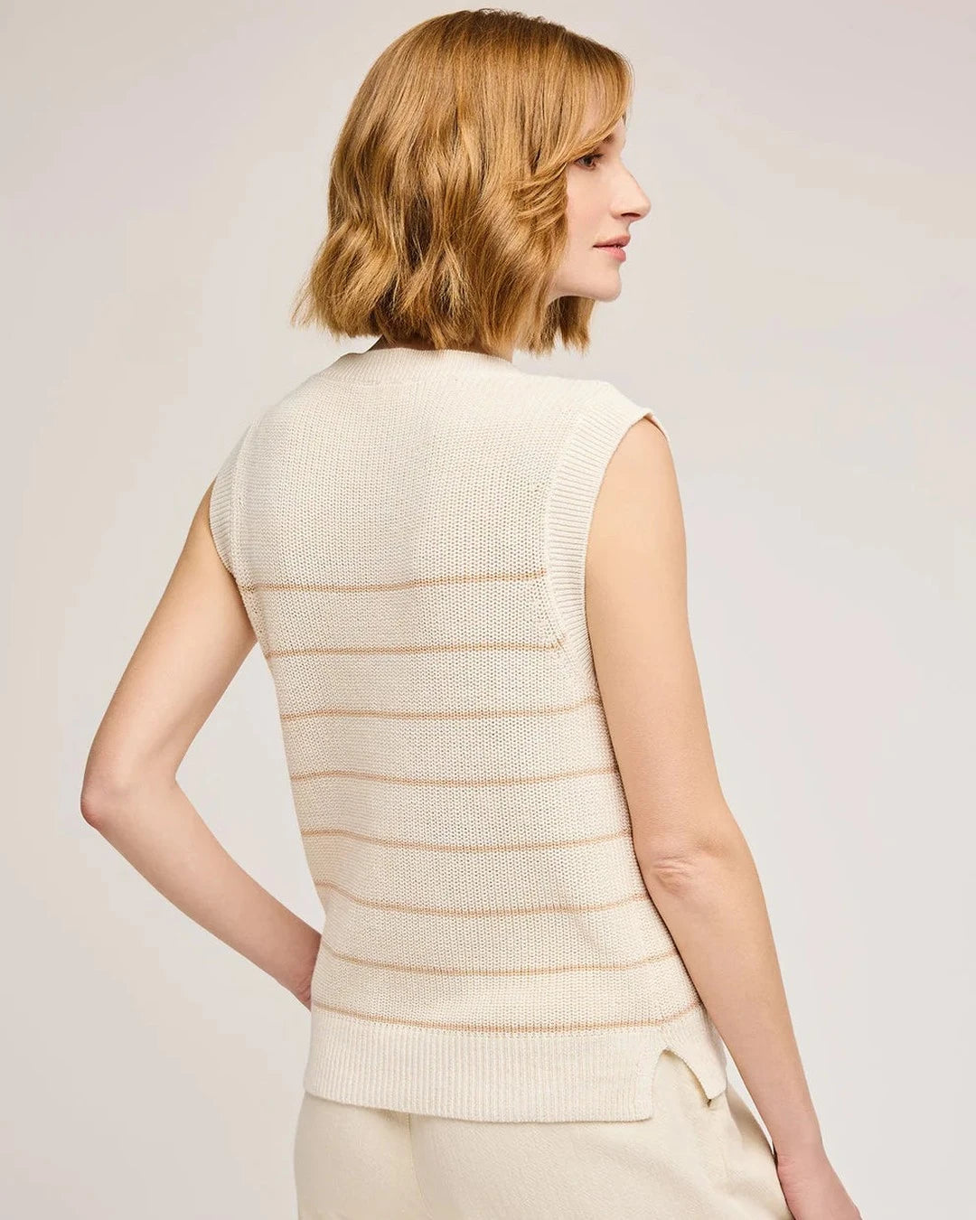 Back view of the cream and tan striped Tanner sweater vest showing the side slit