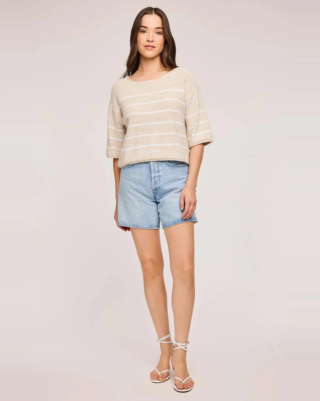 Full-length view of the Kerrigan sweater in Linen with denim shorts and white strappy sandals