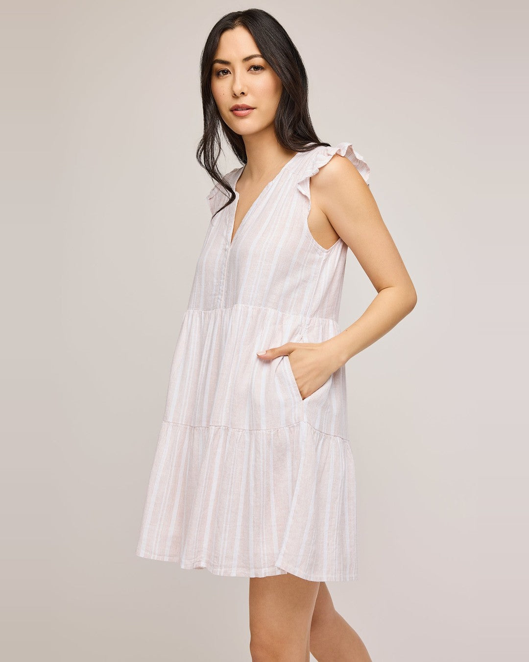 Side view of the pink striped Maggie Mini Dress with a hand in the side pocket