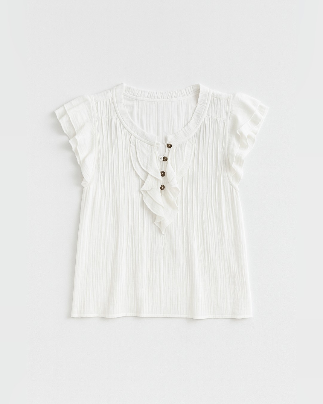 Flat lay of the white Maude Sleeveless Ruffle Button-Up Blouse showing pintucks and button placket
