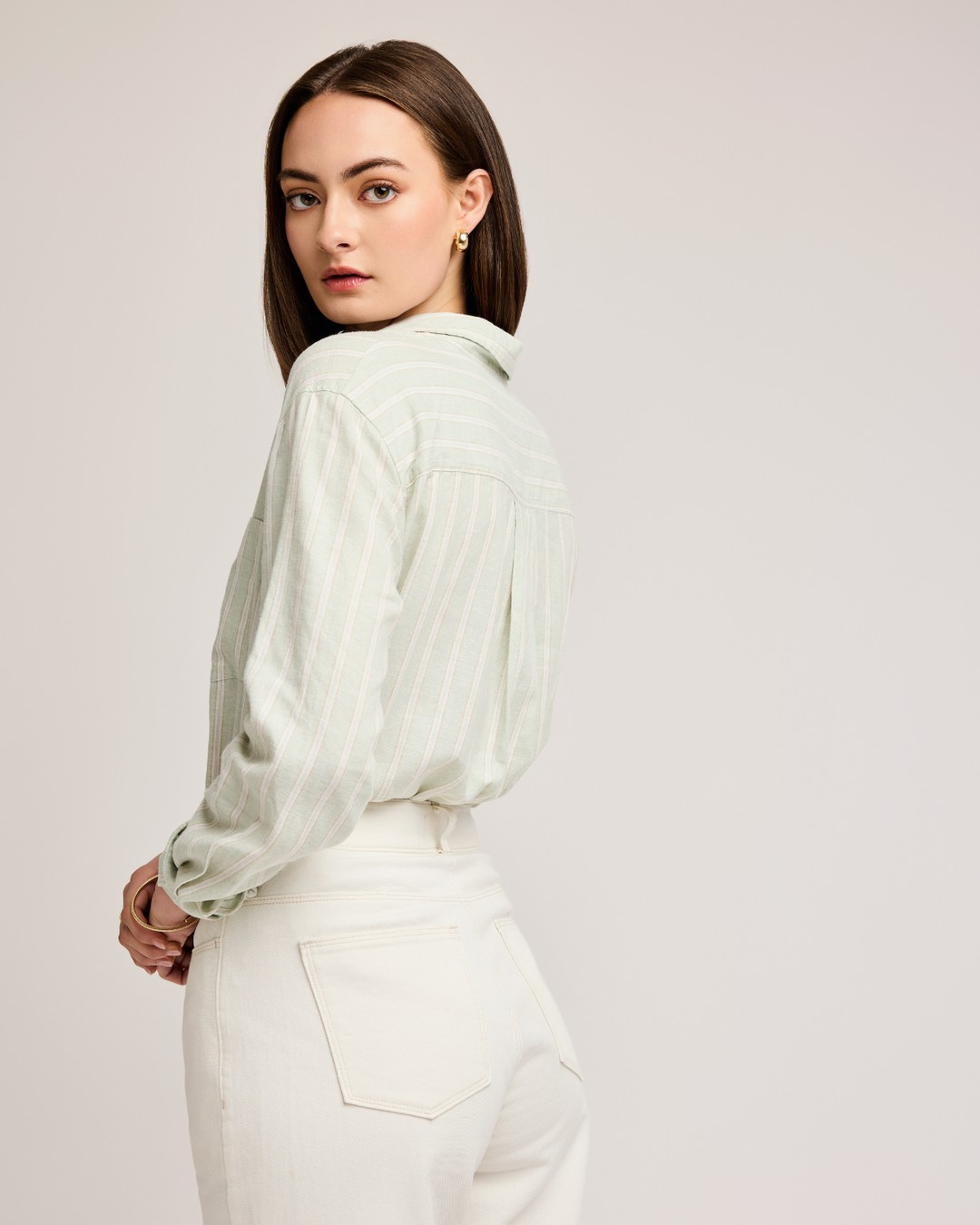 Back view of the Gentle Fawn Dominique mint striped shirt tucked into white jeans