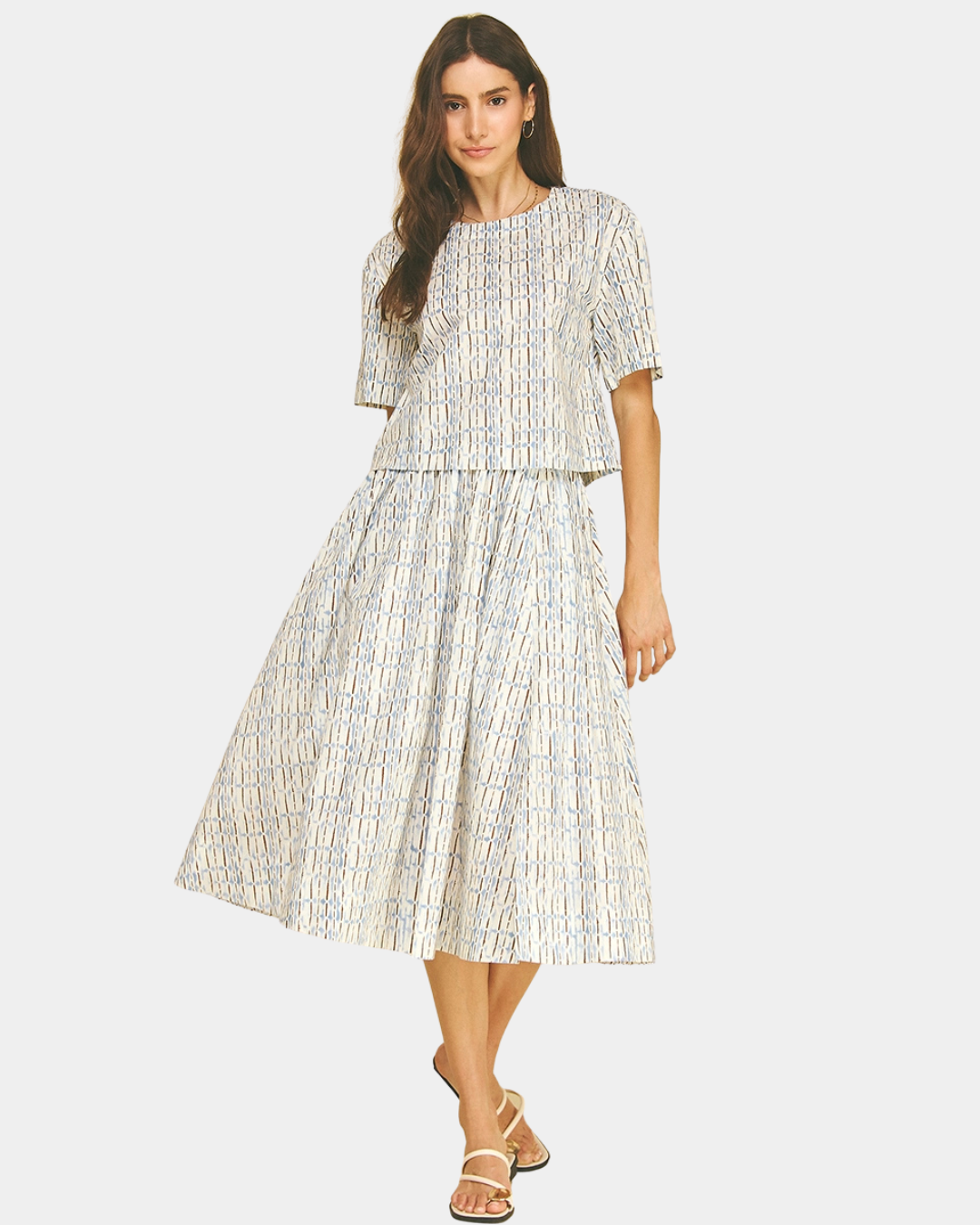Model wearing the Azure Horizon Top matching set featuring a soft blue and ivory print with a relaxed silhouette and coordinating midi skirt.