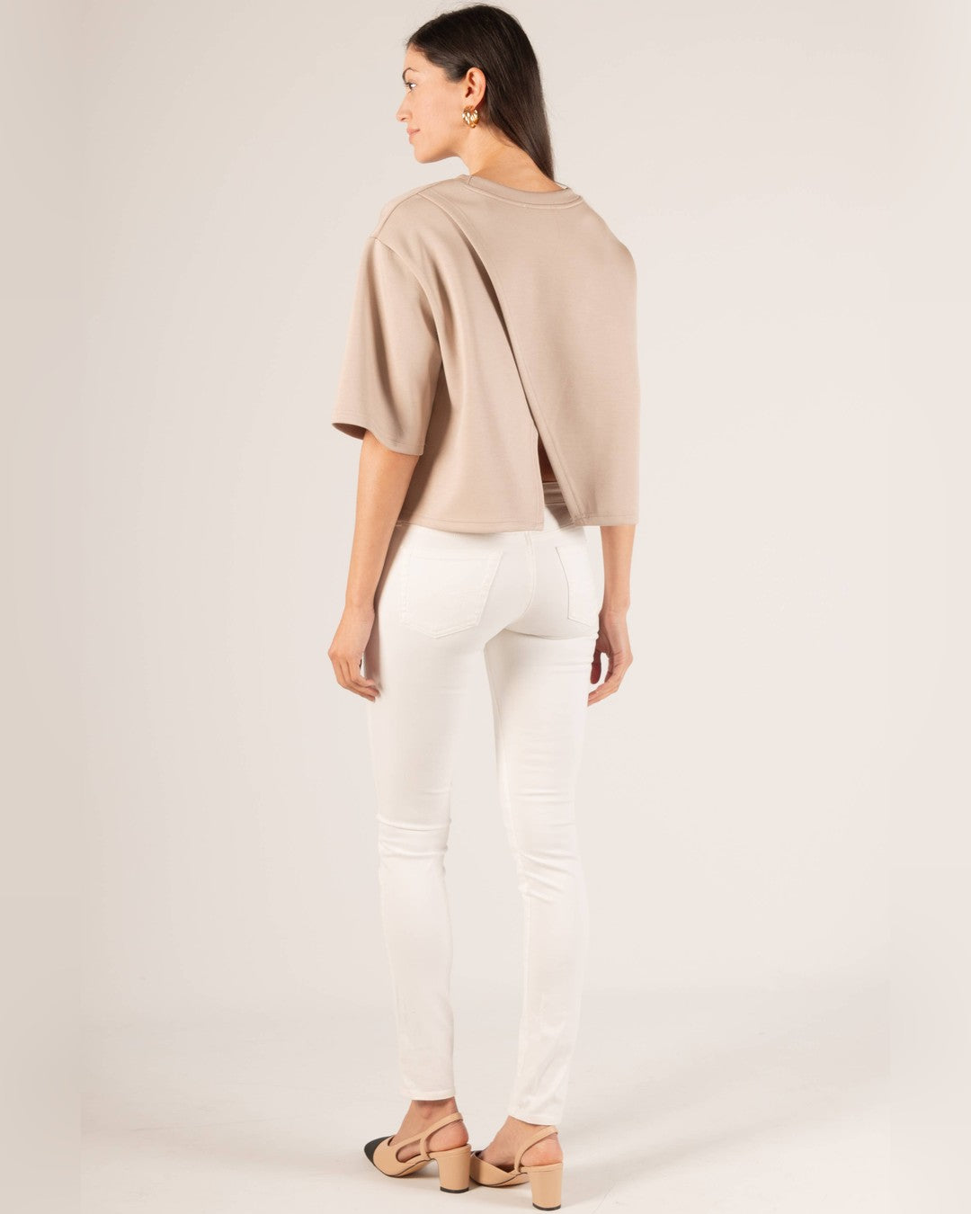 Back view of the taupe P.CILL Hazel Overlap Back Top over white jeans and slingback heels