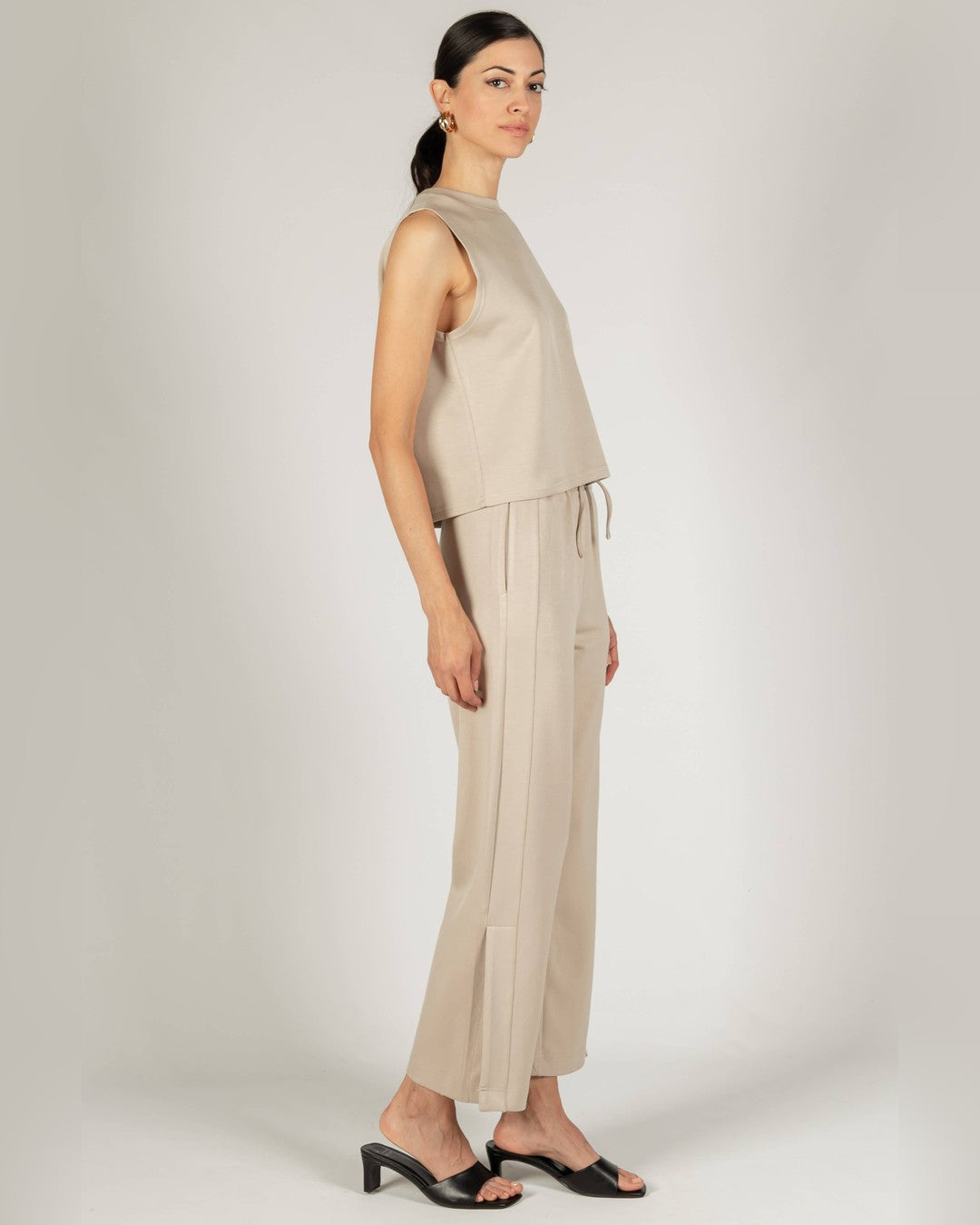 Side view of the taupe P.CILL Birdie tank and matching wide-leg pants with black sandals