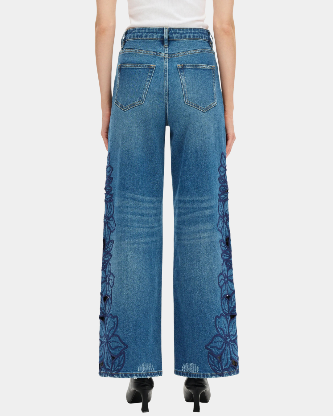 Back view of Bayeas high rise wide leg jeans in medium blue with tonal floral embroidery and cutout detailing.